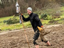 Mitarbeiter in Arbeitskleidung steht in nassem, matschigem Lössboden.